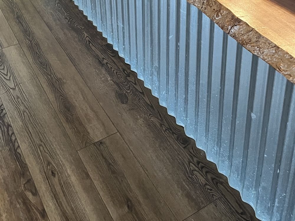 Live-edge slab meeting corrugated galvanized facing on a service counter